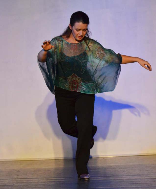a dancer in a graceful pose wearing a diaphanous green shawl
