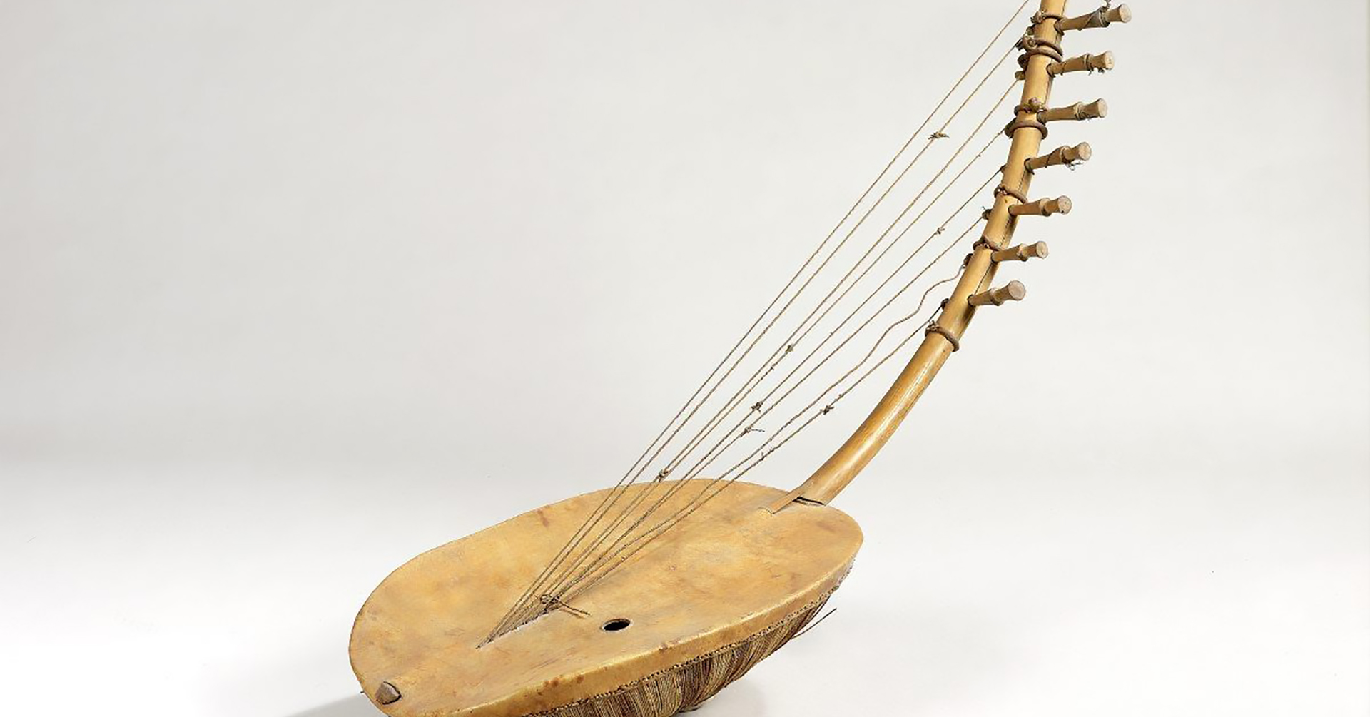 an ennanga, which is a wooden southeast asian harp with a curved neck and bowl-shaped resonator