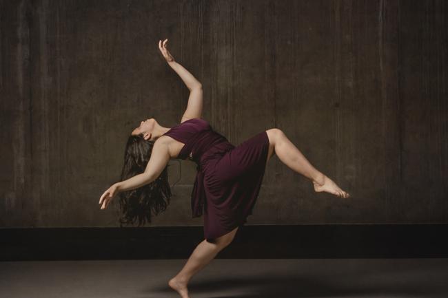 Dancer in a flowing burgandy dress striking a dramatic pose
