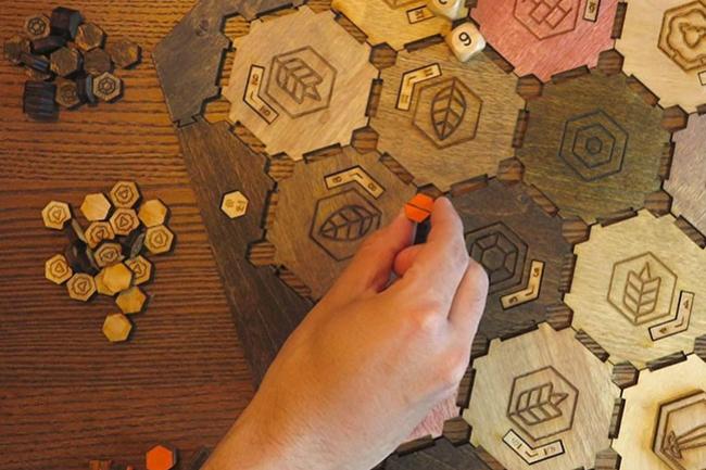 a game made of hexagonal wood tiles with woodburned designs on them