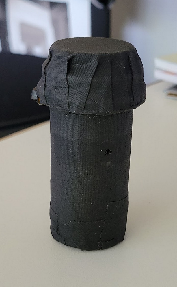 canister or tube wrapped in black material, with a small hole in the side
