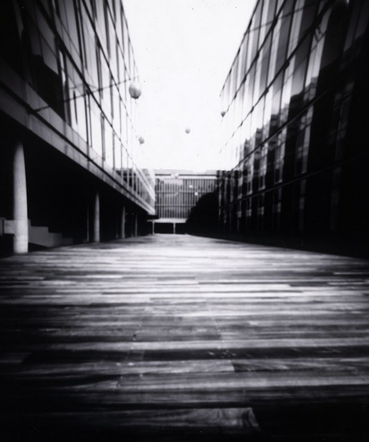 photo of a walkway between two modern buildings, with strong perspective angles converging in the center