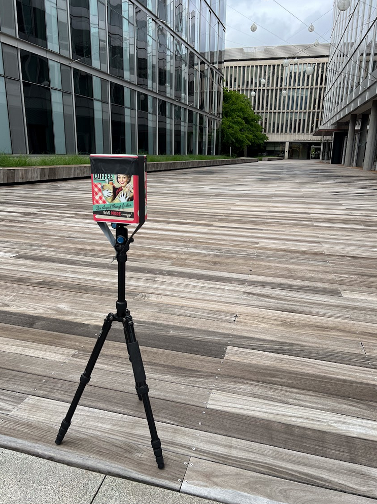 photo of a handmade camera set up on a wood walkway between modern buildings