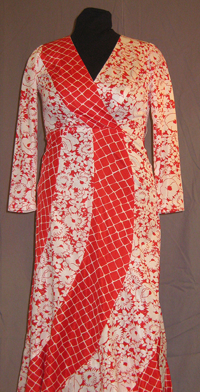 Kimono-style dress with bold red checker motif and bright floral motif. V-neck, full length, full sleeve.