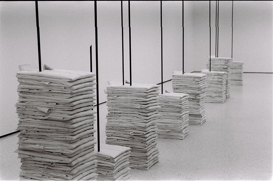 abstract sculpture: seven stacks of tile centered on vertical poles.