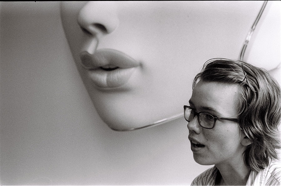 student speaking in front of large image of lips and nose