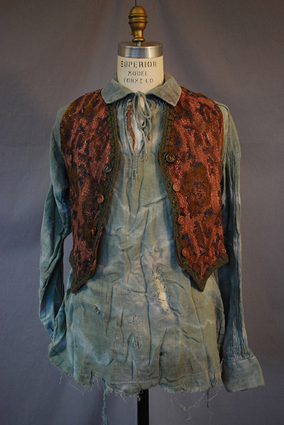 dishevelved grey peasant shirt, worn brown vest with dark pattern