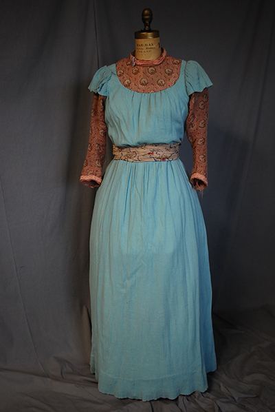 blue prairie dress with rust colored sleeves and neck/collar