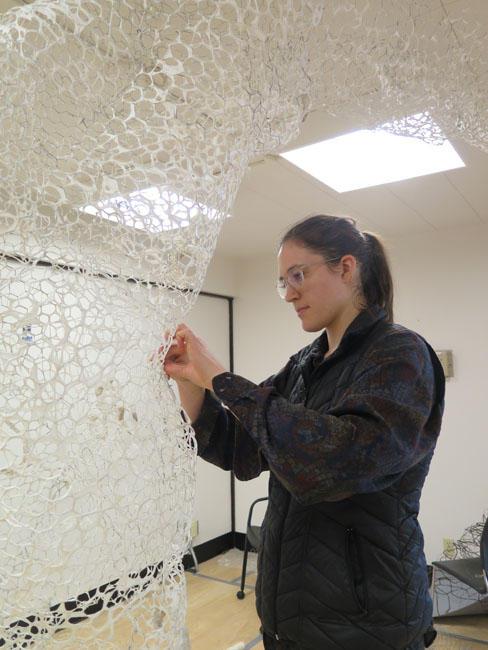 art student working on a 3-D textile sculpture