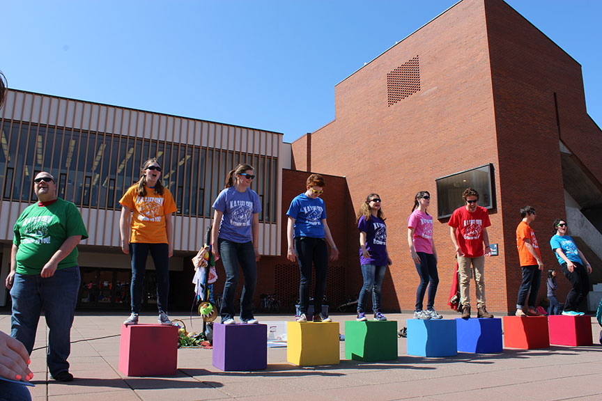 Student performers stand on colorful boxes in Wright Plaza at WWU