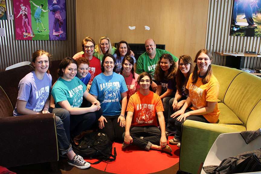 The MOTley ensemble: students in brightly colored shirts seated in a group, flashing friendly smiles at the camera.