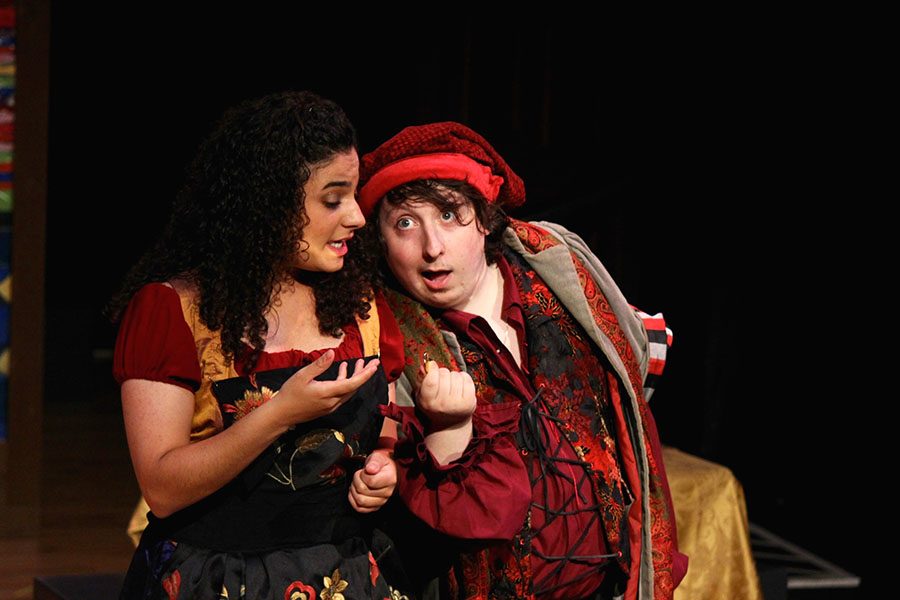 two actors in renaissance costume exchanging a secret