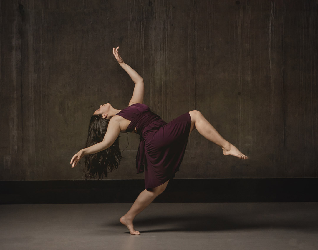 Dancer in a flowing burgandy dress striking a dramatic pose