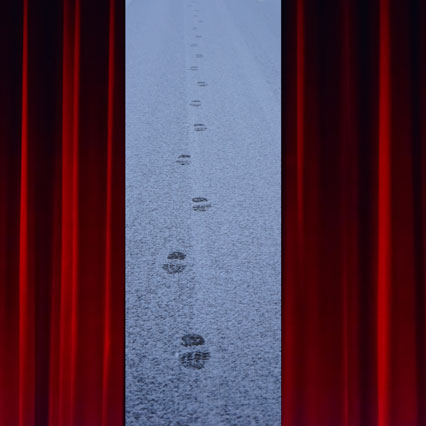 between theatre curtains appears fresh footprints on a snowy road