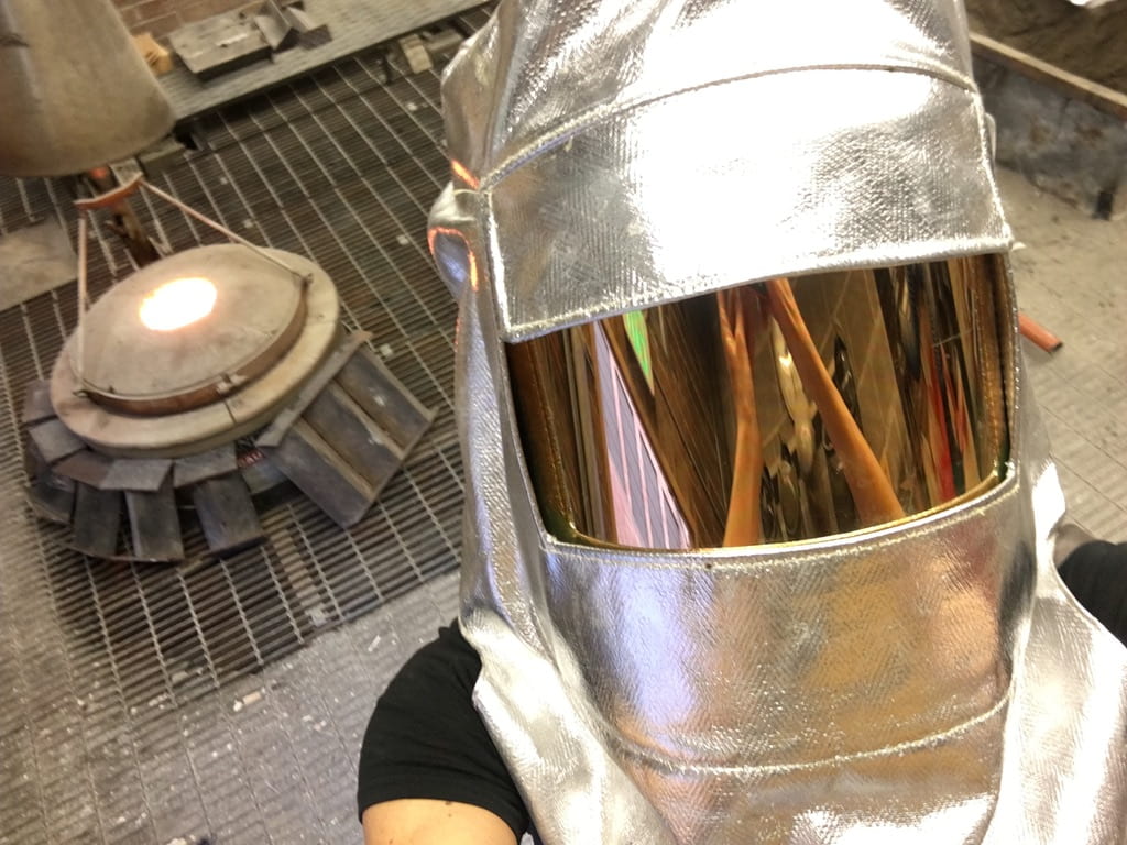 Selfie of a person wearing a welding helmet in an industrial setting
