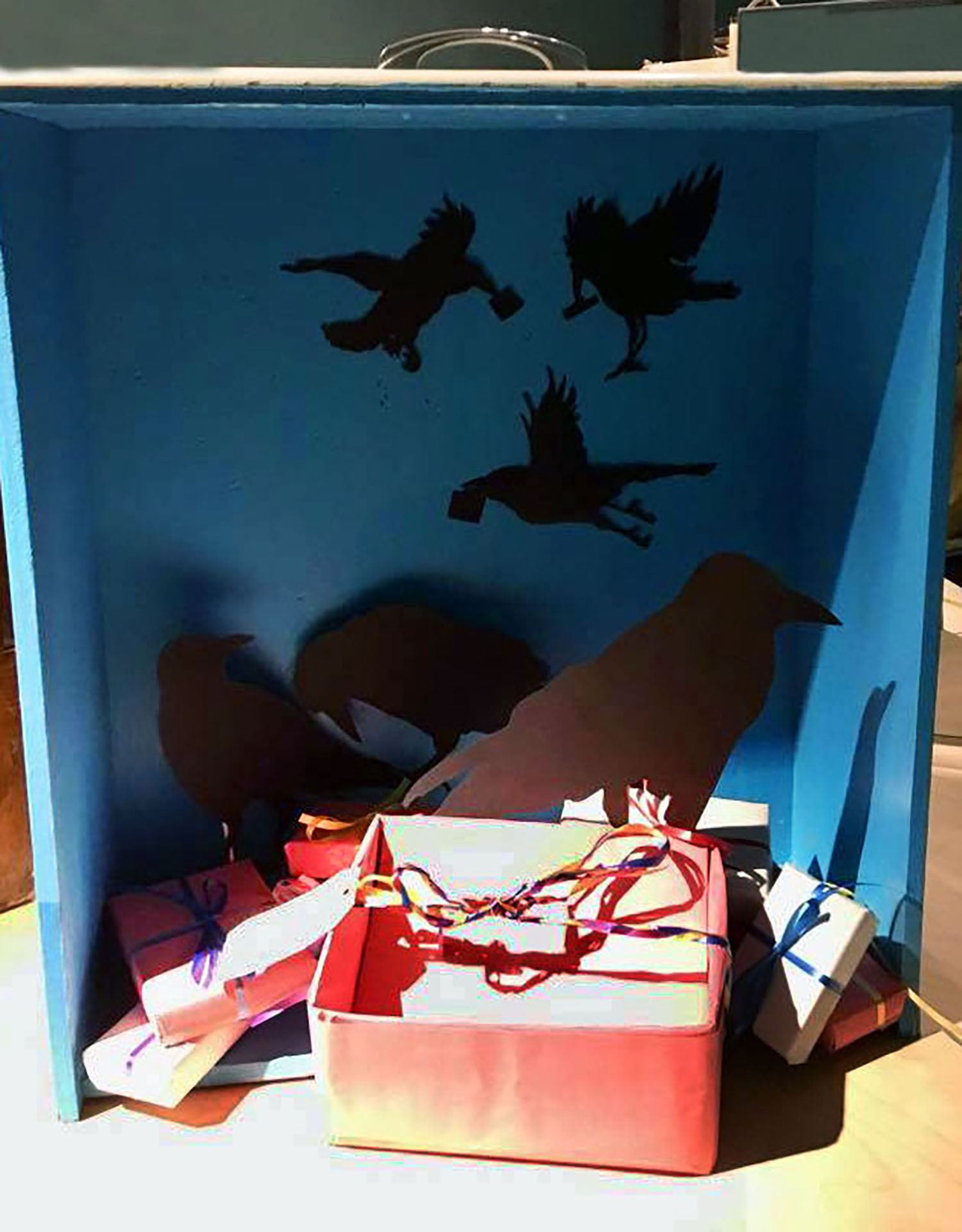 shadowbox display of paper-cutout-crows and gift boxes