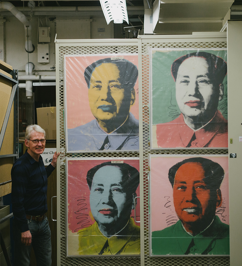 gallery director displays prints of Warhol's Mao