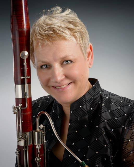 person holding a bassoon and smiling