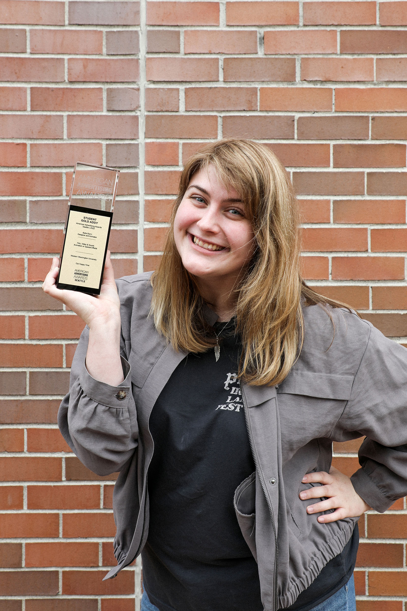 a design student holding a trophy