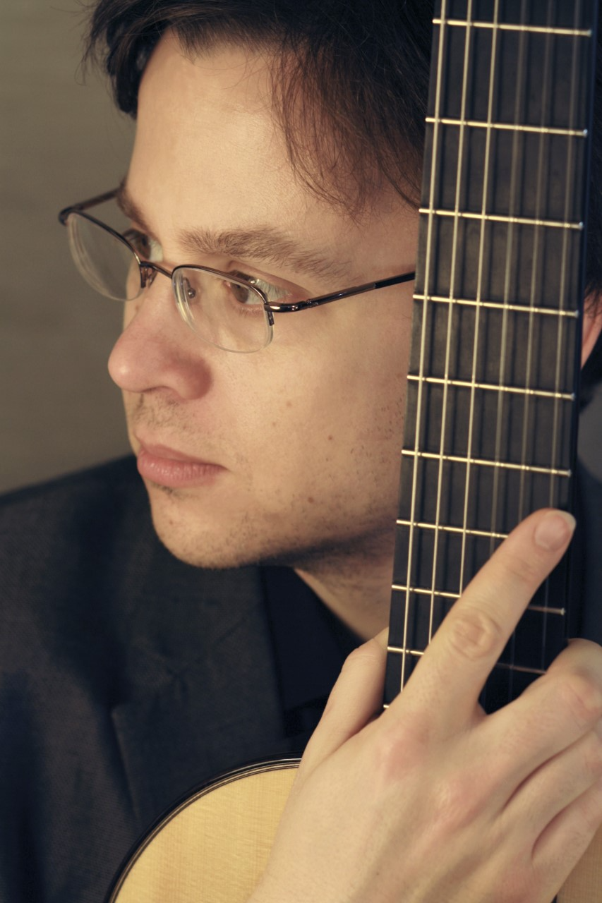 Michael Kudirka's face up close to the stem of a guitar