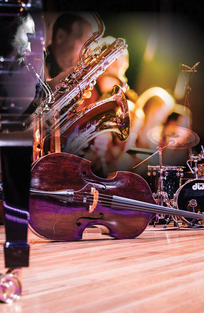 foot-level view of jazz instruments on a stage. In the air above, an imposed image of a group of people playing jazz instruments