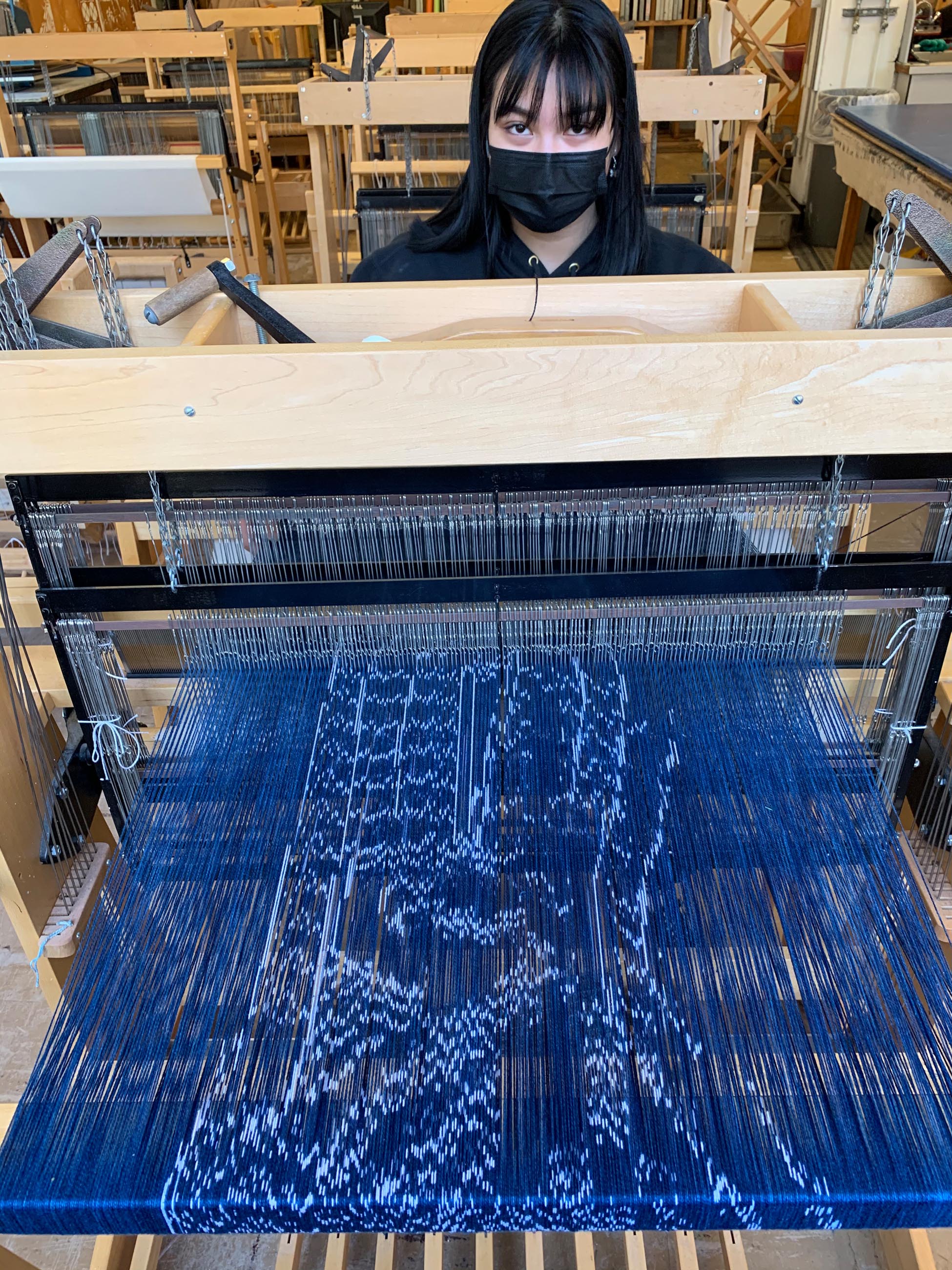 a loom with blue fabric and thread