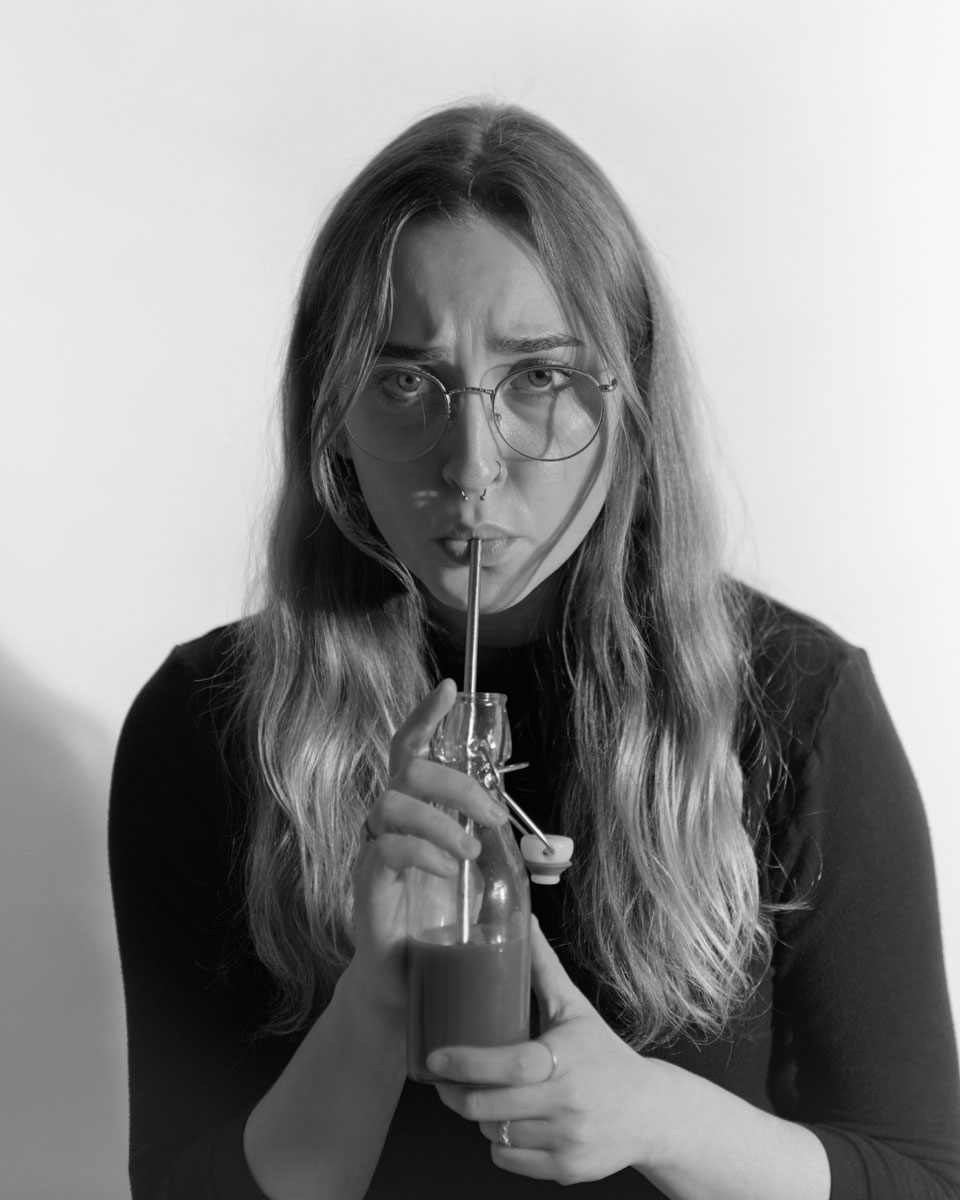 a person nervously sips from a straw