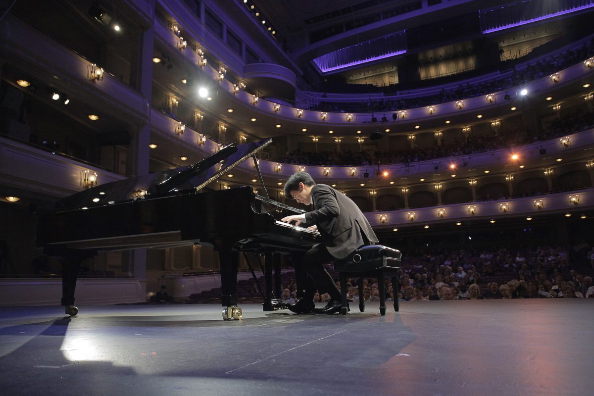 Daniel Hsu playing piano in the Cliburn competition, bent over with his nose close to his hands