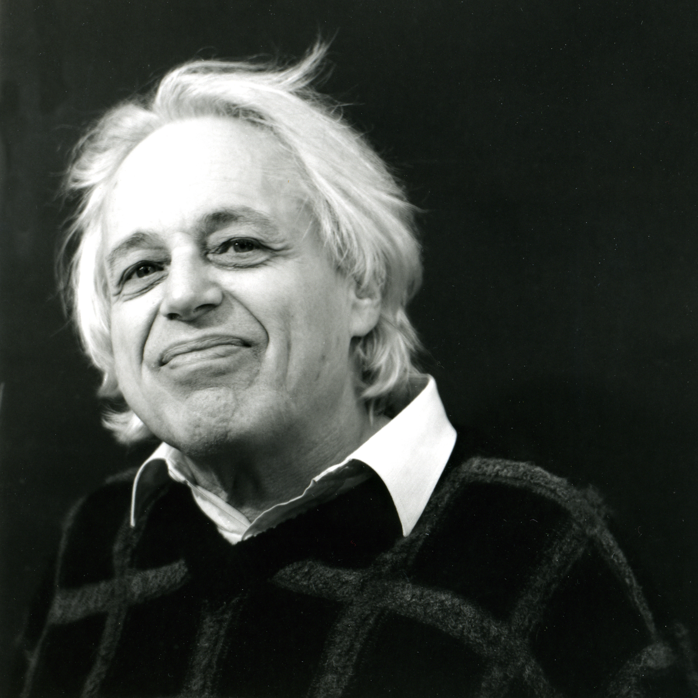 Gyorgy Ligeti, a smiling person with feathery white hair, black sweater with while collar