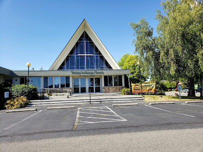 View across a parking lot of a church with a high triangular roof