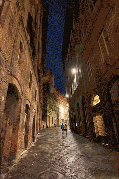 a narrow curving Italian street at night