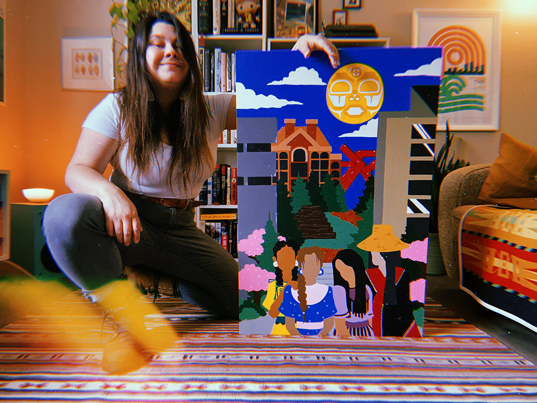 Savannah LeCornu kneels beside a painting in a living room decked with tribal art