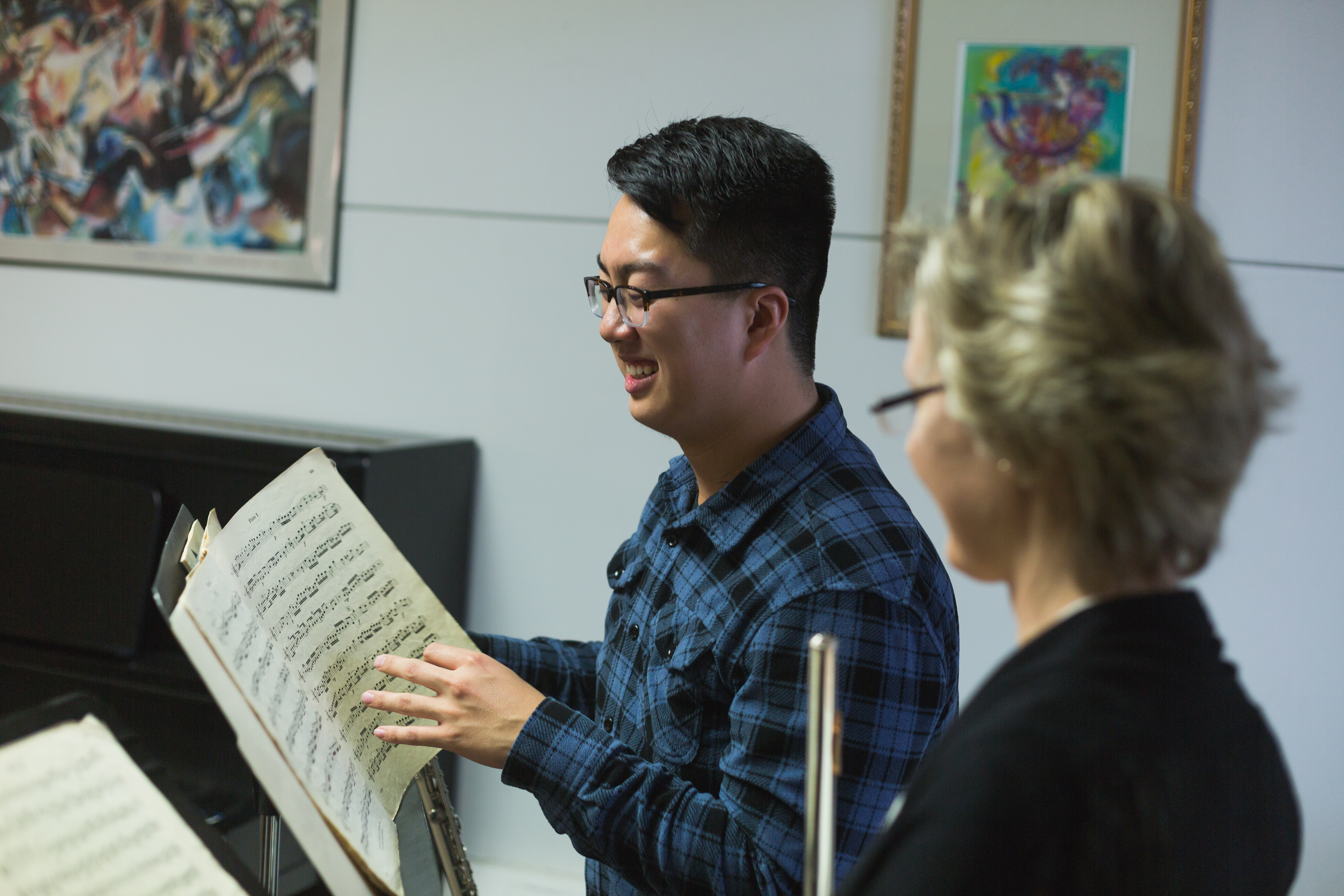 A student and flute faculty member looking at music on stands.