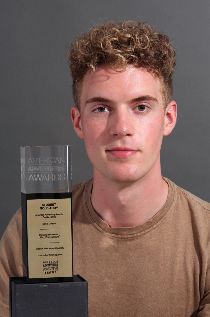 a person in a tan shirt holding an award