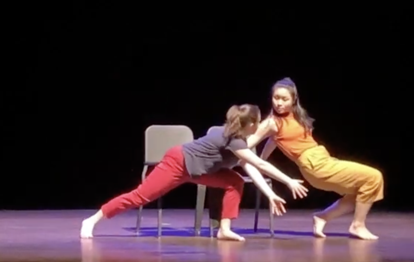 two dancers move about a single chair