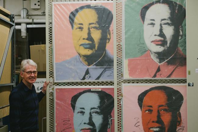 gallery director displays prints of Warhol's Mao