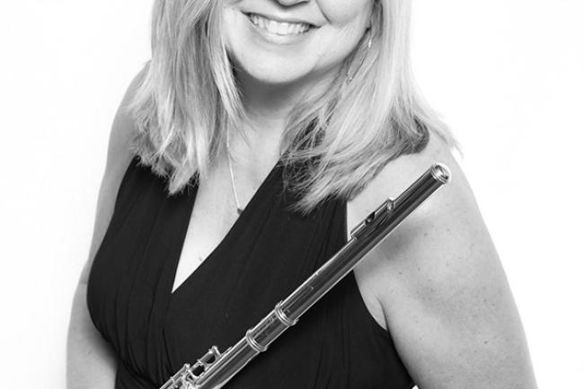 Kimberly standing holding a flute, wearing a formal dress and a friendly smile