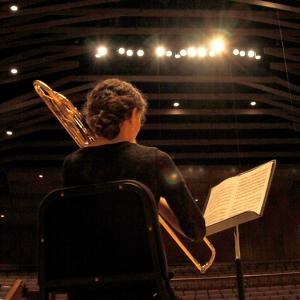 view from behind a student playing an instrument on stage in the Western's Concert Hall