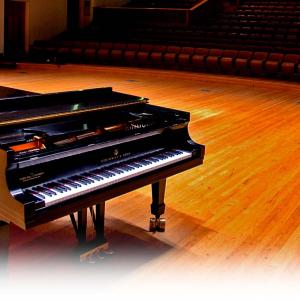 grand piano on wooden stage