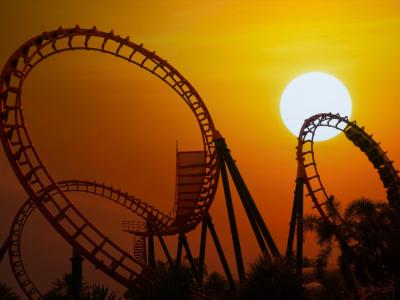 large unoccupied roller coaster silhouetted against an eerie sunset