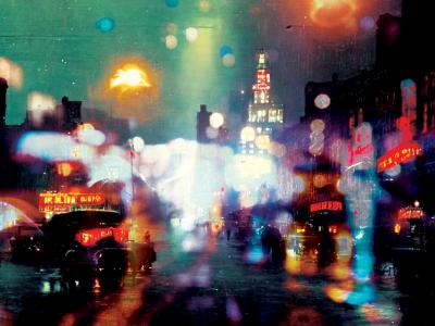grainy, blurry, colorful image: city lights glow and reflect on a rainy street scene