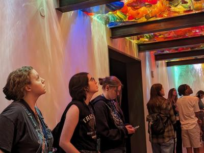 students gazing upward at a colorful installation