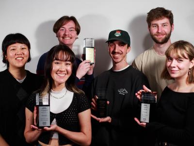 six design students pose holding trophies