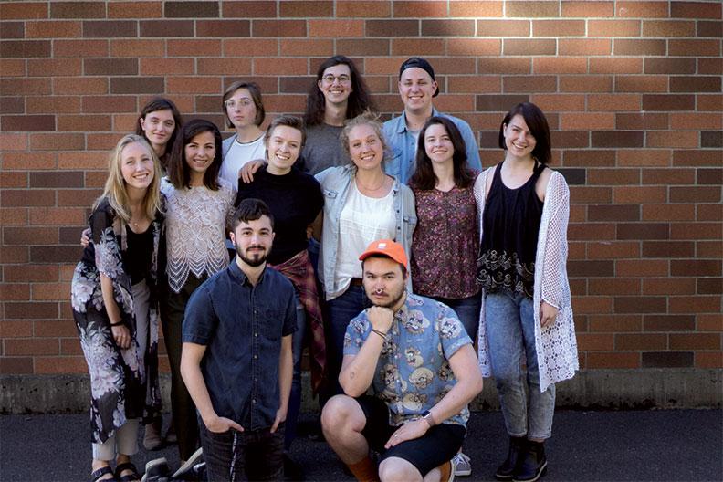 Design students pose in front of a brick wall
