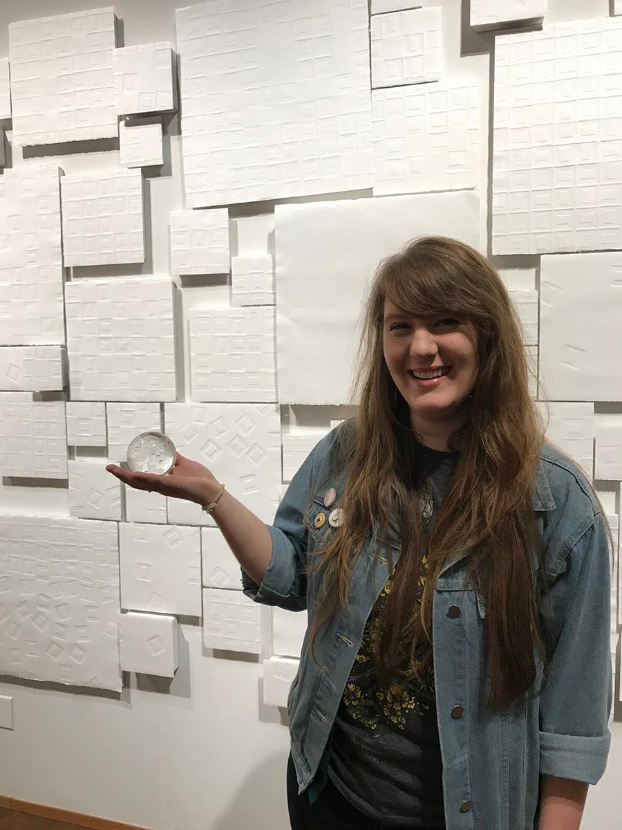 Anastasia DeVol in front of her artwork holding the award