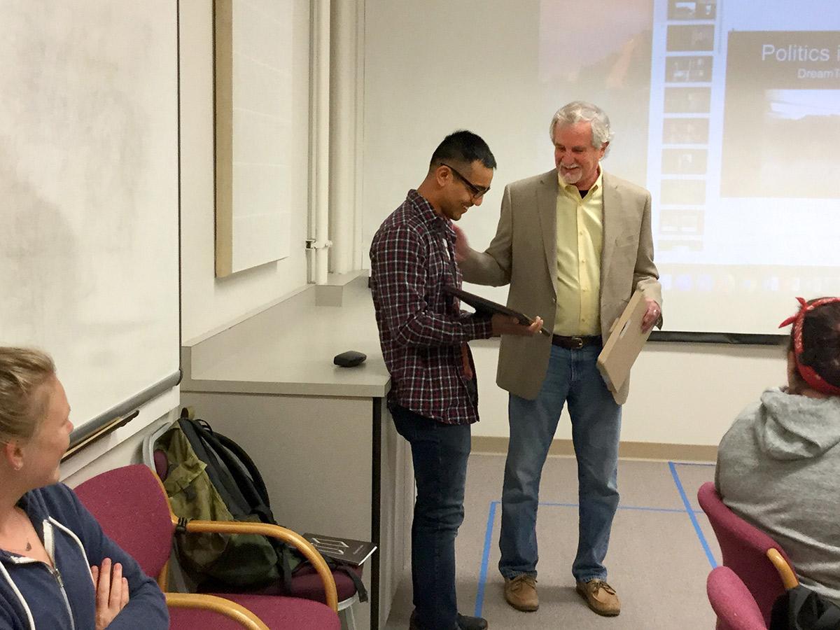 student receives award from dean in a classroom