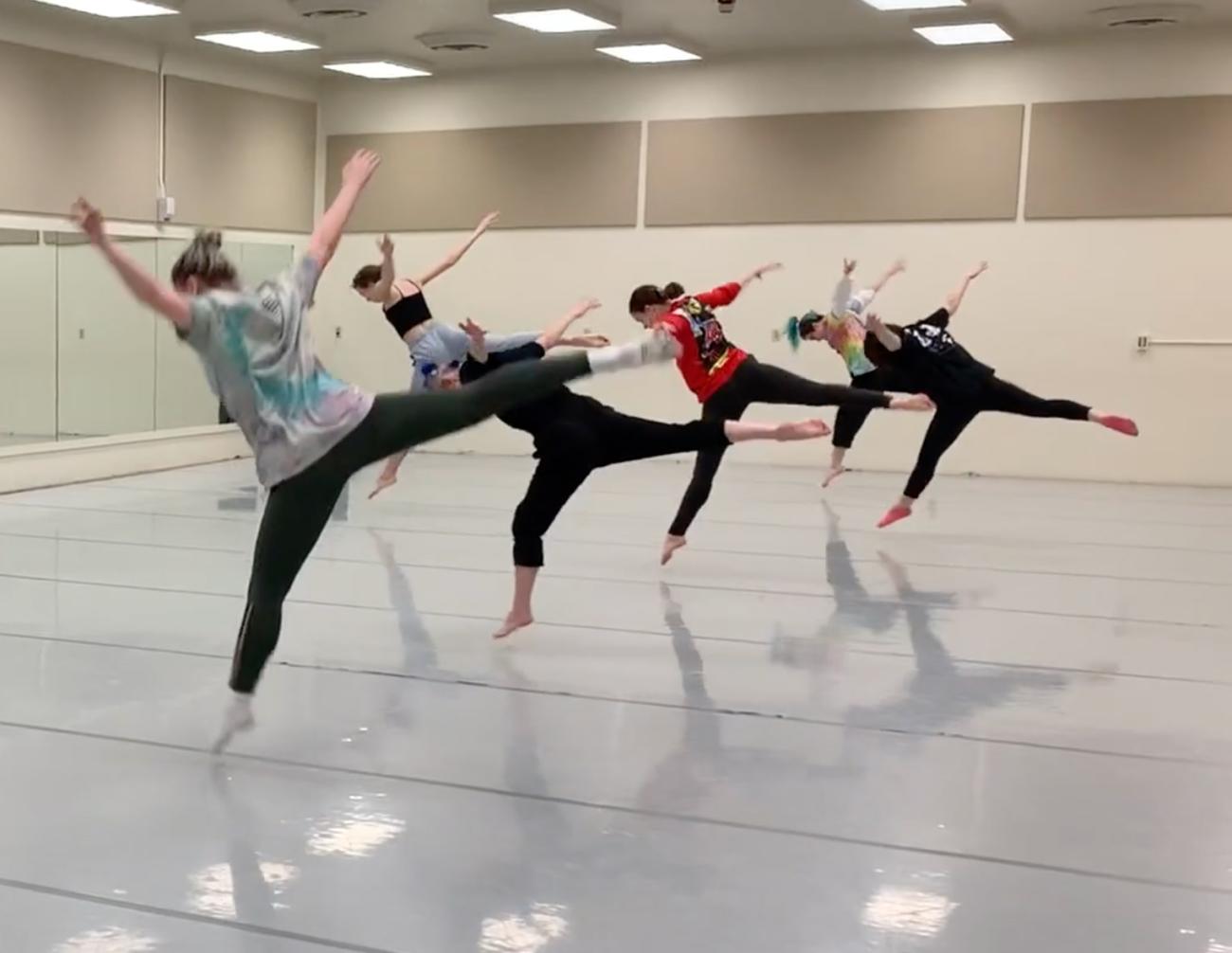 four dancers balance on one foot with back legs and arms extended