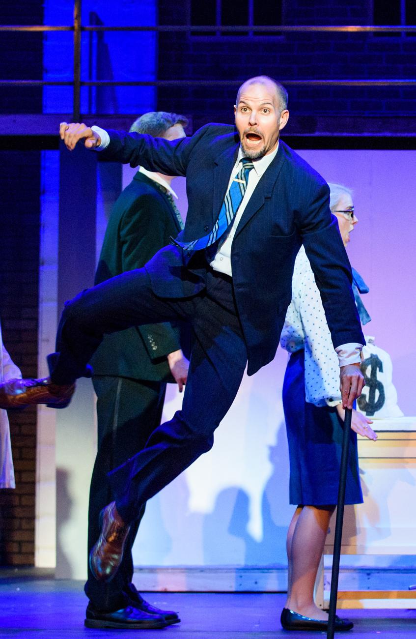 a man in a suit leaps into the air to click his heels