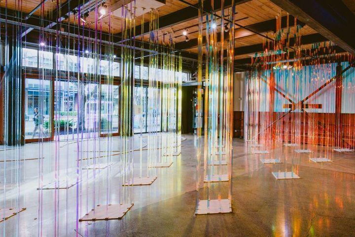 floor to ceiling acrylic rods refract prismatic light throughout the warehouse-like room