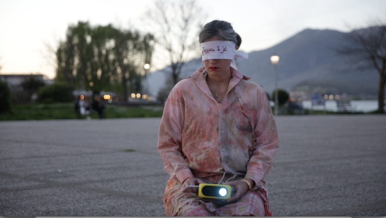 a person sitting in an empty parking lot, blindfolded